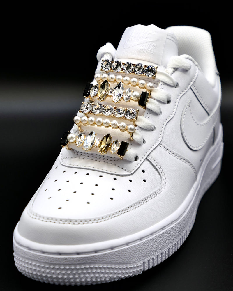 White Nike Air Force 1 and Jordan 1 sneakers with gold,  pearls, black rhinestone shoelace charm decorations