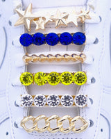 White Nike Air Force 1 and Jordan 1 sneakers with gold,  pearls, yellow and blue rhinestone shoelace charm decorations